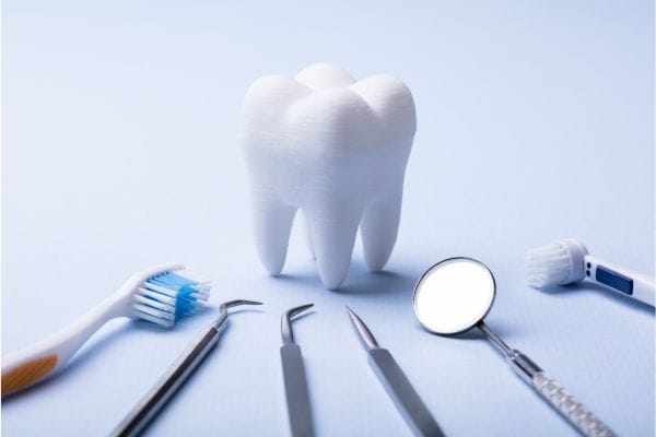 dental instrumen ts on white table with a model of a tooth dental instrumen ts on white table with a model of a tooth