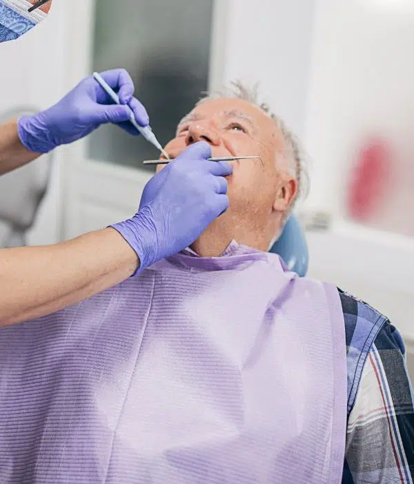 Man sat in dental chair receiving treatment