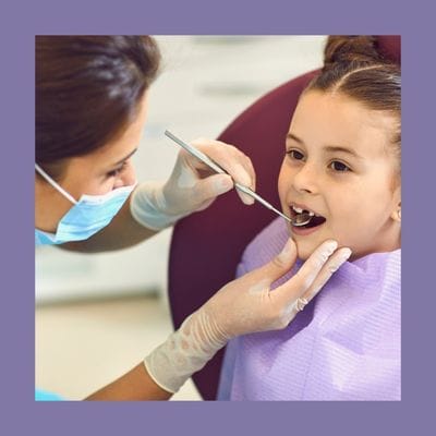 Dentist carrying out childrens dental examination