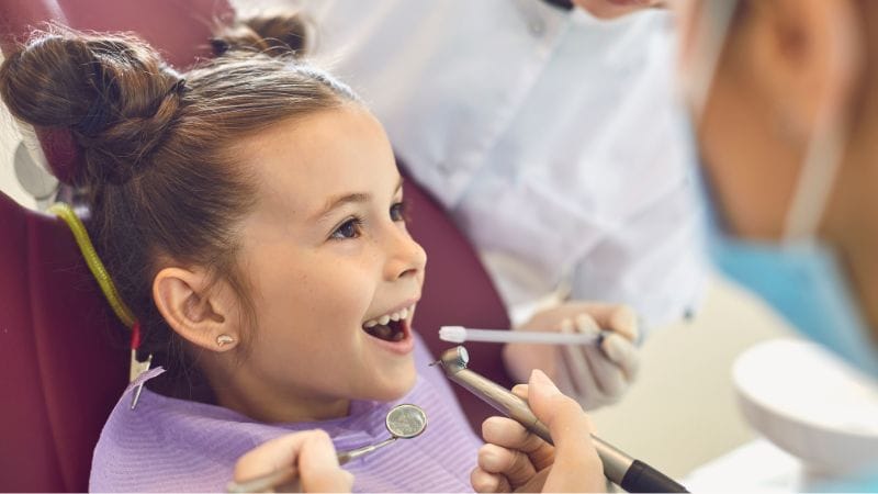 A child sat in a dental chair having a children's dental health check up